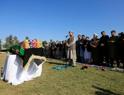 Afghan men pray near the coffin of journalist Malalai Maiwand, who was shot and killed by unknown gunmen in Jalalabad, Afghanistan December 10, 2020. Reuters