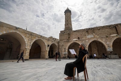 A Palestinian man reads the Quran at the Great Omari Mosque in March 2023. AFP