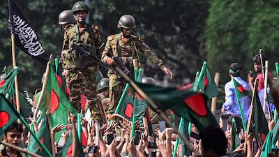 A march towards Prime Minister Sheikh Hasina's palace as army personnel stand guard in the Shahbag of Dhaka. AFP