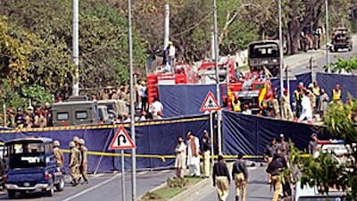 Pakistani Army soldiers and security officials inspect the scene of the suicide bomb attacks.