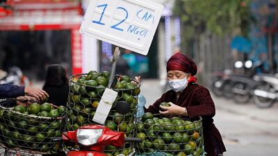 An elderly woman buys oranges on a street in Hanoi, Vietnam. EPA