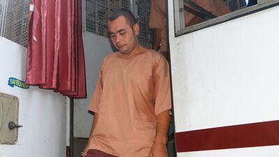 Tarmizi Tohtayong exits a prison bus after arriving at the criminal court in Bangkok, Thailand. AP