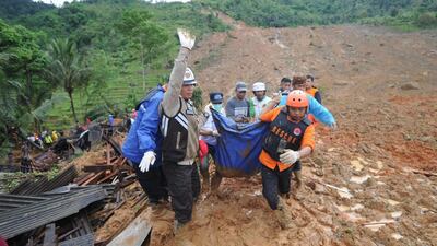 Indonesian rescuers carry the remains of a landslide victim at Sirnaresmi village in Sukabumi, Indonesia. EPA