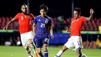 Takefusa Kubo, centre, of Japan vies for the ball with Arturo Vidal and Erick Pulgar of Chile. EPA