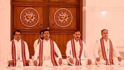 Hindu priests chant prayers in the main prayer hall.