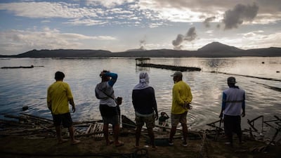 Fishermen make repairs to their operations affected by the ash-fall from the eruption of the Taal volcano, in Buso Buso on January 20. The incident has led to decimated fish, scarred coffee plants and vanished tourists: Ed Jones / AFP