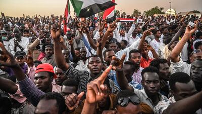 Sudanese protesters gather as they shout slogans and wave national flags during a protest outside the army headquarters in the capital Khartoum. AFP