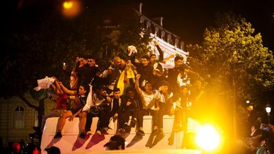 Football fans celebrate on the Champs-Elysees after the African Cup of Nations semifinal soccer match between Algeria and Nigeria in Paris on Sunday, July 14, 2019. Algeria won 2-1. AP Photo