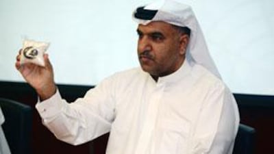 Khalid al Kawari, the deputy director of the anti-narcotics section at Dubai Police, holds a bag of seized amphetamines.