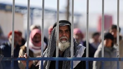 Detainees behind a gate after the Syrian government took control of Al Hol. Reuters