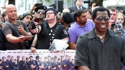 Fans take a selfie as cast member Wesley Snipes poses for a photograph as he arrives for the world premiere of The Expendables 3 . Paul Hackett / Reuters