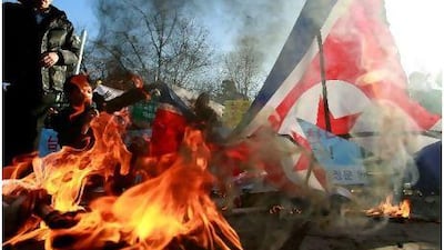 North Korean defectors burn the North Korean flag yesterday in front of the South Korean Defence Ministry in Seoul. Tensions remain high after an artillery exchange on Yeonpyeong island. Chung Sung-Jun / Getty Images