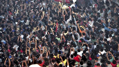 Members of a mob take photos of a man, top centre, lynched and strung up from the clock tower in Dimapur city, in the northeastern Indian state of Nagaland, in 2015. Imojen Jamir / AP