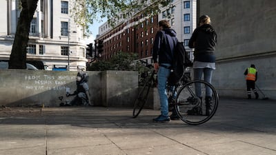 People stop to look at a new piece of street art which is believed to be by Banksy. Getty Images