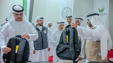 Officials look at school and stationery supplies included in a shipment bound for Gaza. Sharjah International Airport, 19th August 2026. Photo: Ahmed Ramzan / The National
