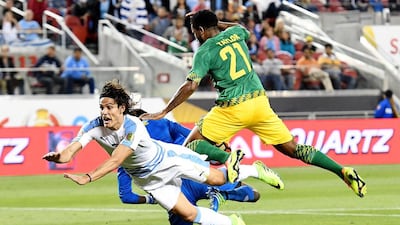 Edinson Cavani of Uruguay, left, gets tripped up by goalkeeper Andre Blake and Jermaine Taylor of Jamaica. Thearon W Henderson / Getty Images