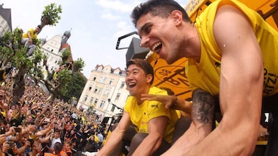 Dortmund's Marc Bartra, right, and Shinji Kagawa celebrate the club's German Cup victory with fans on May 28, 2017. Ina Fassbender / AFP