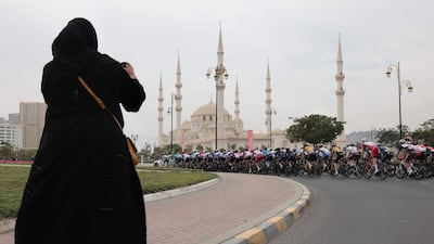 A supporter takes a picture as the pack rides during the fifth stage of the UAE Tour. AFP