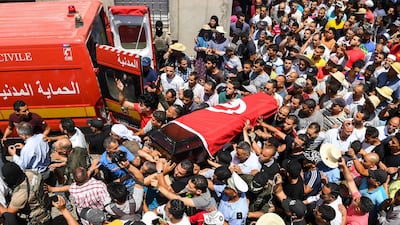 Mourners carry the coffin of killed Sgt Arbi Guizani, one of six security Tunisian officers killed on Sunday, at his funeral in Tunis on July 9, 2018. Fethi Belaid / AFP