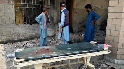 Hospital staff gather at the site of a bombing on an entrance of a hospital in Dera Ismail Khan, Pakistan. AP