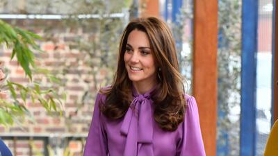The Duchess of Cambridge wears a purple Gucci blouse and Jigsaw wide-leg trousers, topped off with a lilac Aspinal of London bag to visit the Henry Fawcett Children's Centre in Kennington, London, on Tuesday March 12. AP
