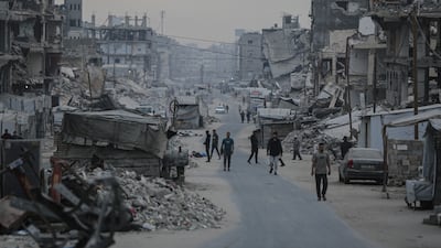 Palestinians walk among rubble during Eid Al Adha in Gaza city. Bloomberg