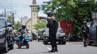 A policeman manages the traffic after an explosion outside a church in Makassar. AFP