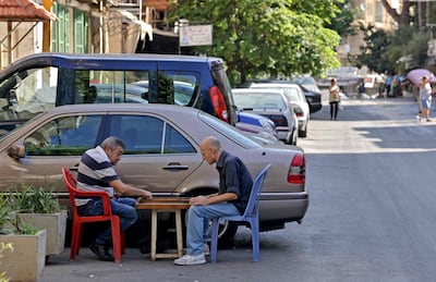 Lebanese men play backgammon in the Christian neighbourhood of Ain Al Remmaneh, adjacent to the area of Tayouneh, in the southern suburb of the capital Beirut on October 15, 2021, a day after deadly clashes. AFP