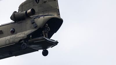 A Chinook helicopter flies over Camp Mystic after picking up troops that aided in search and recovery efforts. AFP