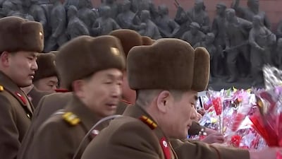 North Korean military personnel lay flowers in front of giant statues of Kim Il Sung and Kim Jong Il on Mansu Hill in central Pyongyang, KRT / AP