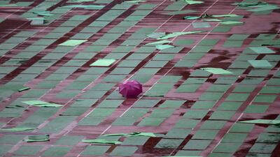 An umbrella lies amidst wet yoga mats as the capital enjoyed a spell of rain ahead of International Yoga Day in New Delhi. Tsering Topgyal / AP Photo