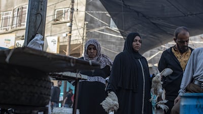 Displaced Palestinians shop for food at a market in Khan Younis refugee camp. EPA