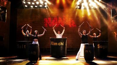 Nanta take the stage for their comic kitchen performance. Below, players enjoy a game of Yut. Courtesy PMC Co; Sameeha Studio