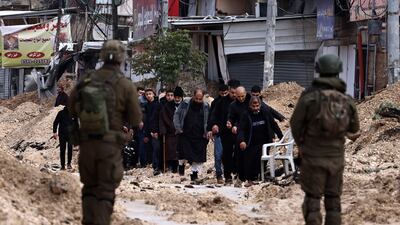 Israeli soldiers watch residents of Nur Shams refugee camp near Tulkarm on Monday. The UN relief agency for Palestinians says a weeks-long Israeli military operation has displaced about 40,000 in the West Bank. AFP