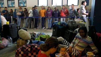 Venezuelan migrants rest while another group stands in line to enter am immigration office in Tumbes, Peru, Saturday, Aug. 25, 2018. AP