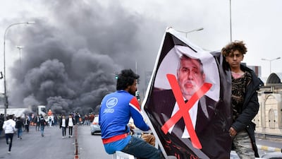 Iraqi demonstrators lift a poster of premier-designate Mohammad Allawi with the mention "rejected" during an anti-government protest in the southern city of Nasiriyah. AFP