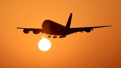 An Emirates plane lands at Dubai International Airport at sunrise. AFP