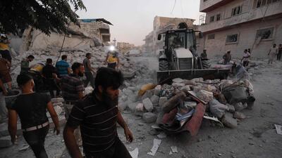 Members of the Syrian Civil Defence (White Helmets) clear debris during their search for survivors following a reported air strike by Syrian regime forces in Maaret Al Numan in Syria's north-west Idlib province on August 28, 2019. AFP