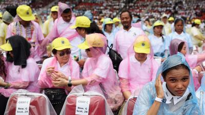 Catholic worshippers wear raincoats as they wait for the start of the holy mass by Pope Francis at the Gelora Bung Karno Stadium in Jakarta. AFP