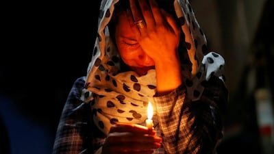 A woman cries as she holds a lit candle for the victims of the blast in Kabul on June 1, 2017. Mohammad Ismail / Reuters