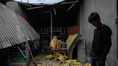Marvin Rodriguez stands inside his kitchen covered in ash. AFP