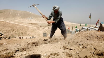 An Afghan man digs graves for the victims of yesterday's suicide attack in Kabul. Reuters