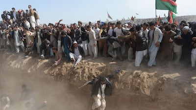 Supporters of presidential candidate Ashraf Ghani jump to cross a ditch as they leave after a gathering on the outskirts of Kunduz province, north of Kabul. March 19, 2014. Shah Marai / AFP