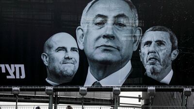 A pedestrian overpass beneath a giant Blue and White (Kahol Lavan) alliance electoral billboard showing the face of Israeli Prime Minister Benjamin Netanyahu (C) flanked by Justice Minister Amir Ohana (L) and Education Minister Rafi Peretz (R) in the central Israeli city of Ramat Gan on March 1, 2020, a day before the country's third election in a year. / AFP / MENAHEM KAHANA