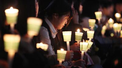 A high school student holds a candle to pay her respect to the victims of the sunken ferry Sewol during a ceremony on the eve of the second anniversary of the ferry sinking in Ansan, South Korea. Two year ago, as South Korea writhed in grief and fury after more than 300 people, most of them school kids, drowned in a ferry sinking, it seemed things would never be the same. Ahn Young-joon / AP photo
