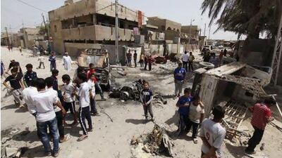 Residents gather at the site of a car bomb attack in the Kamaliya district in Baghdad.