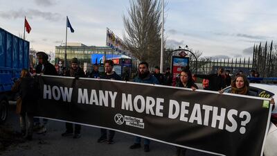 Activists from international climate action group Extinction Rebellion hold a banner reading "how many more deaths?" after dumping manure outsideCOP25. AFP