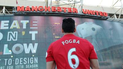 A Manchester United fan wearing a replica shirt bearing the name of Manchester United’s new midfielder Paul Pogba stands outside the stadium ahead of the Premier League match between Manchester United and Southampton at Old Trafford, Manchester, Britain, 19 August 2016. Peter Powell / EPA