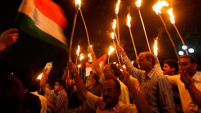 August 18, 2011: Supporters of Anna Hazare hold torches and an Indian national flag during a protest rally against corruption in Kolkata. REUTERS/Rupak De Chowdhuri