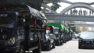 Policemen sit inside trucks parked on a road in the downtown area of Yangon, Myanmar. AP